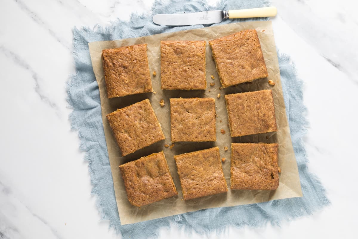Sourdough blondie squares sliced and cooling on parchment paper after baking.