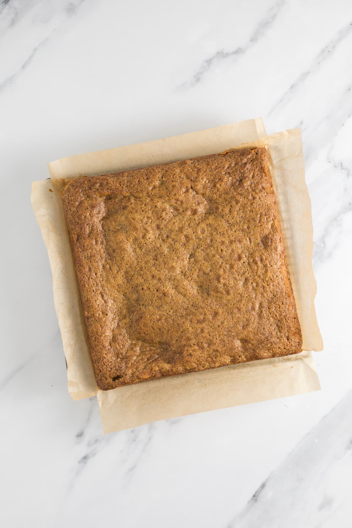 Freshly baked sourdough blondies cooling on parchment paper after baking.
