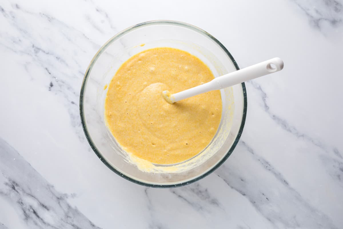 Mixed sourdough cornbread muffin batter in a mixing bowl before being transferred to a muffin pan.