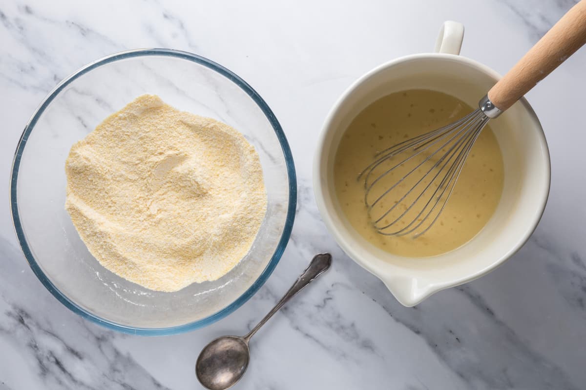 Wet ingredients and dry ingredients prepared in separate bowls before making sourdough cornbread muffin batter.