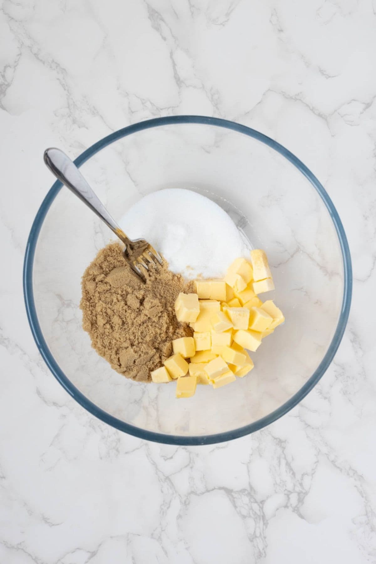 Butter, brown sugar, and white sugar in a mixing bowl before creaming for sourdough peanut butter cookies.