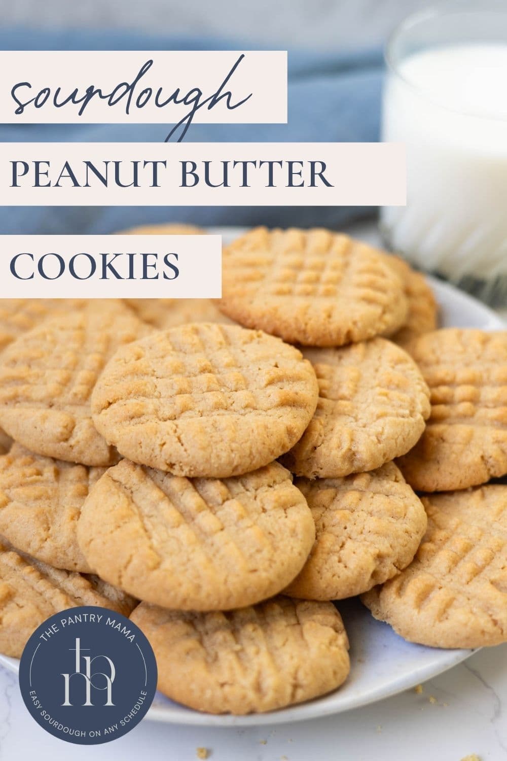 Soft sourdough peanut butter cookies arranged on a plate with a glass of milk and text overlay reading "Sourdough Peanut Butter Cookies."