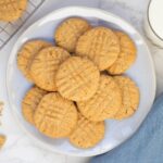 Golden sourdough peanut butter cookies with classic fork marks arranged on a serving plate.