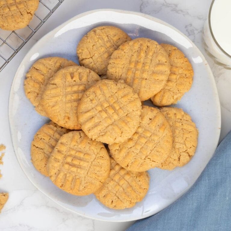 Golden sourdough peanut butter cookies with classic fork marks arranged on a serving plate.