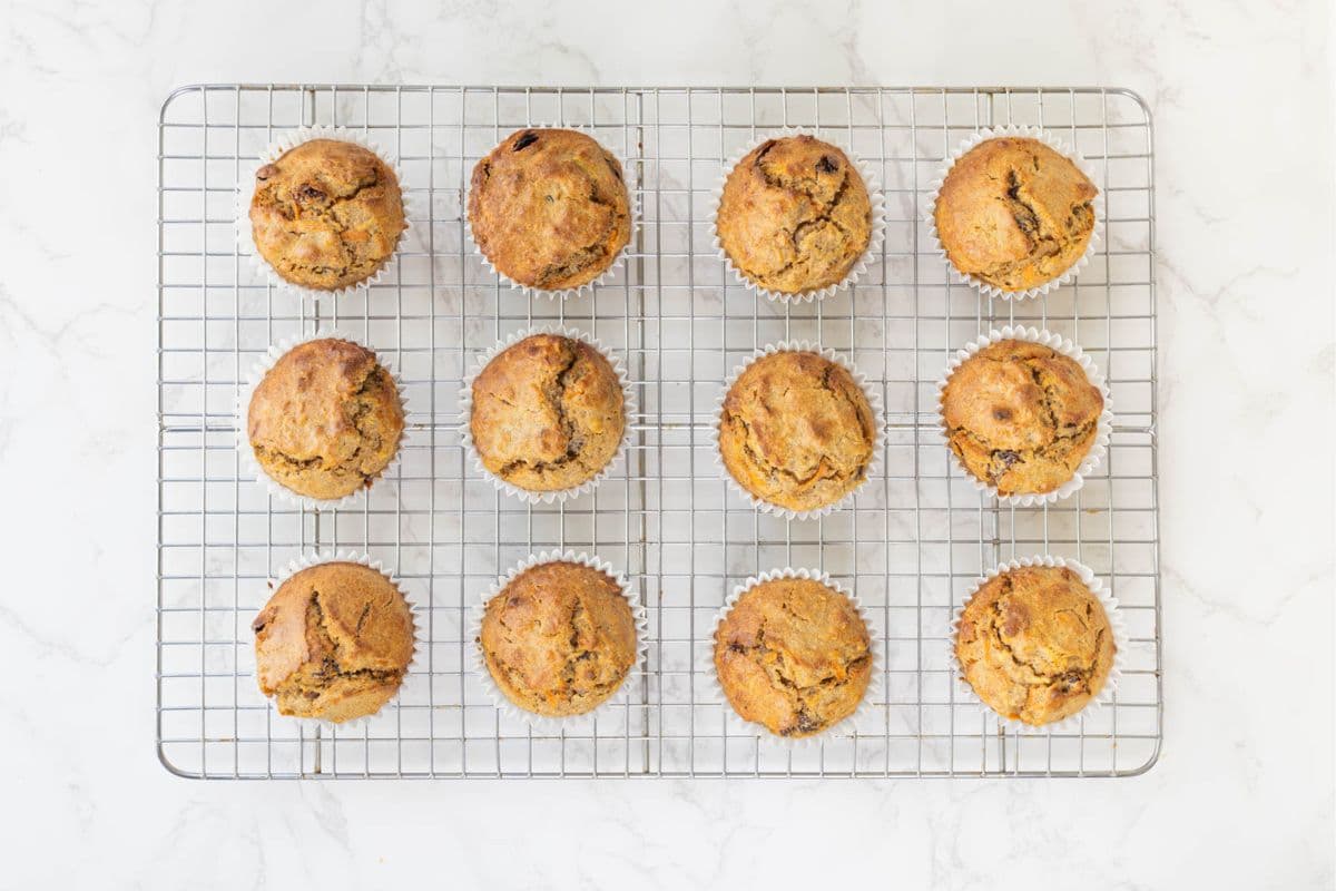 Sourdough morning glory muffins cooling on a wire rack after baking.