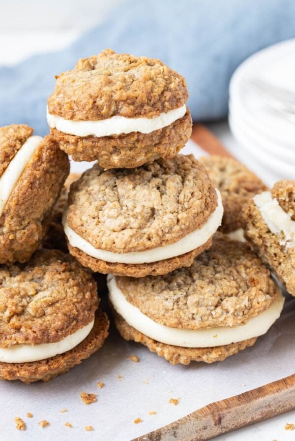 Several sourdough oatmeal cream pies stacked together on parchment paper.