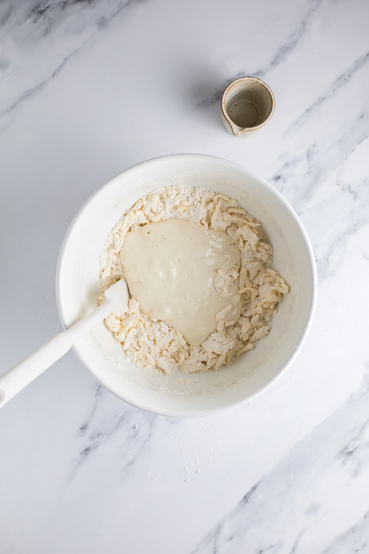 Sourdough starter poured over the flour and butter mixture to make sourdough pie crust dough.
