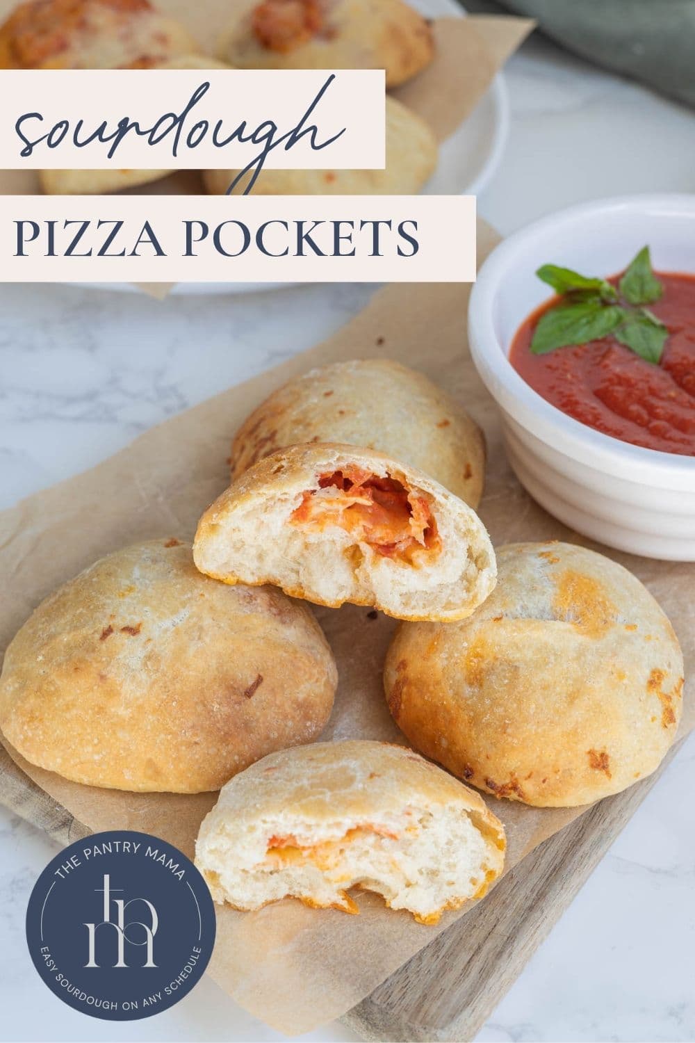 Easy sourdough pizza pockets stacked on a serving board with one broken open to show pizza fillings inside and text overlay for a Pinterest Pin image.