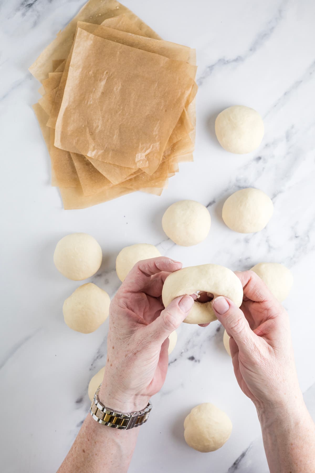 Stretching the center hole of a sourdough bagel to help it stay open during proofing and baking.