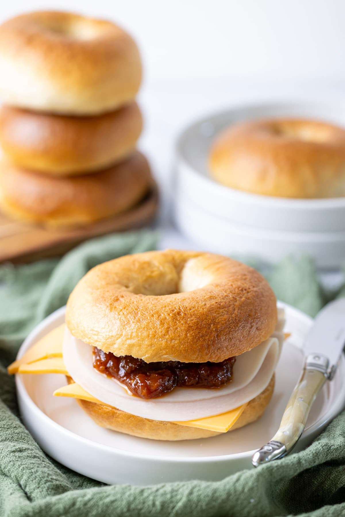 Homemade sourdough bagel sandwich filled with cheese, deli meat and chutney.