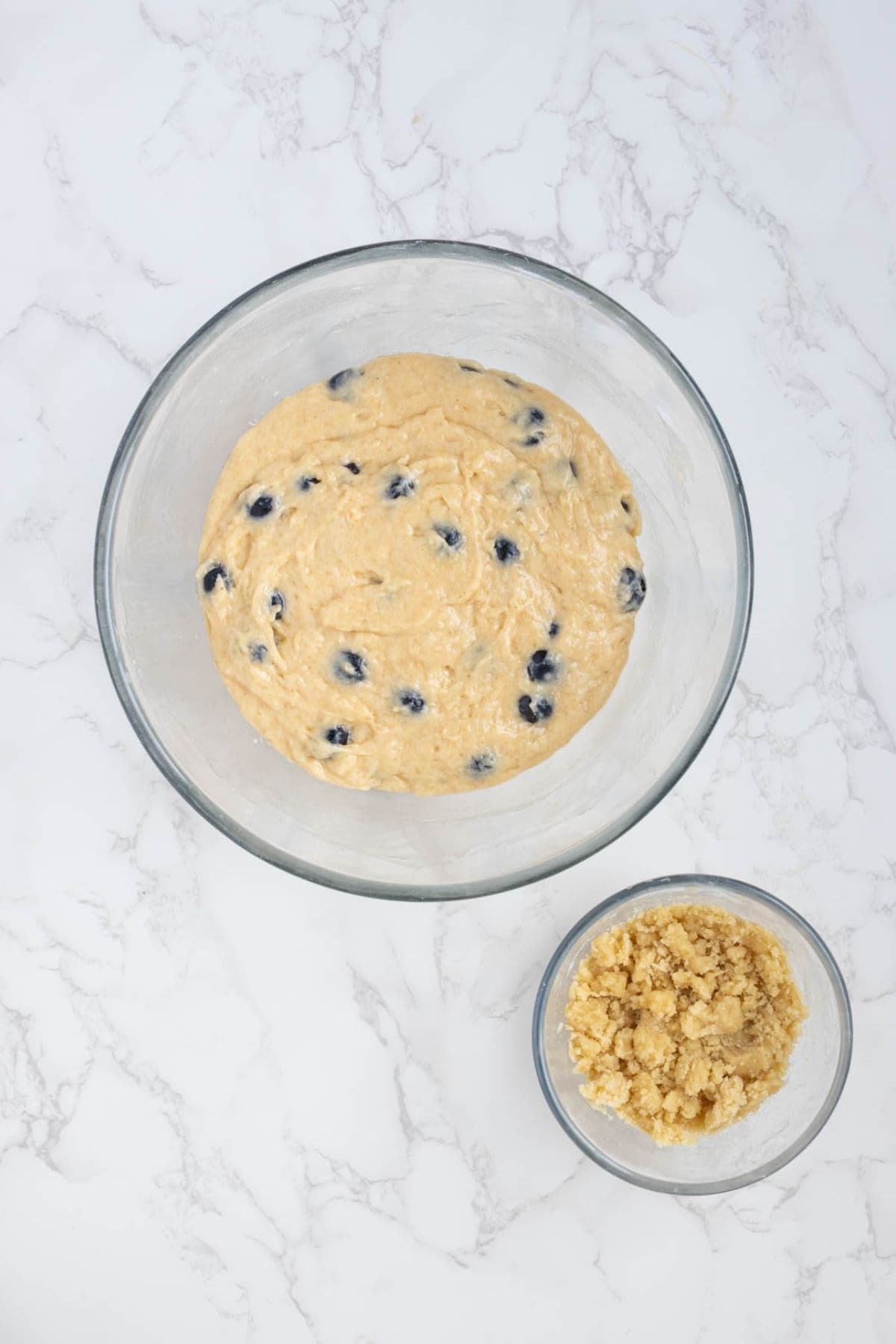 Blueberry muffin batter made with sourdough starter folded together with fresh blueberries and streusel topping.
