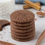 Stack of sourdough chocolate snickerdoodle cookies served on parchment paper with cinnamon sticks in the background.
