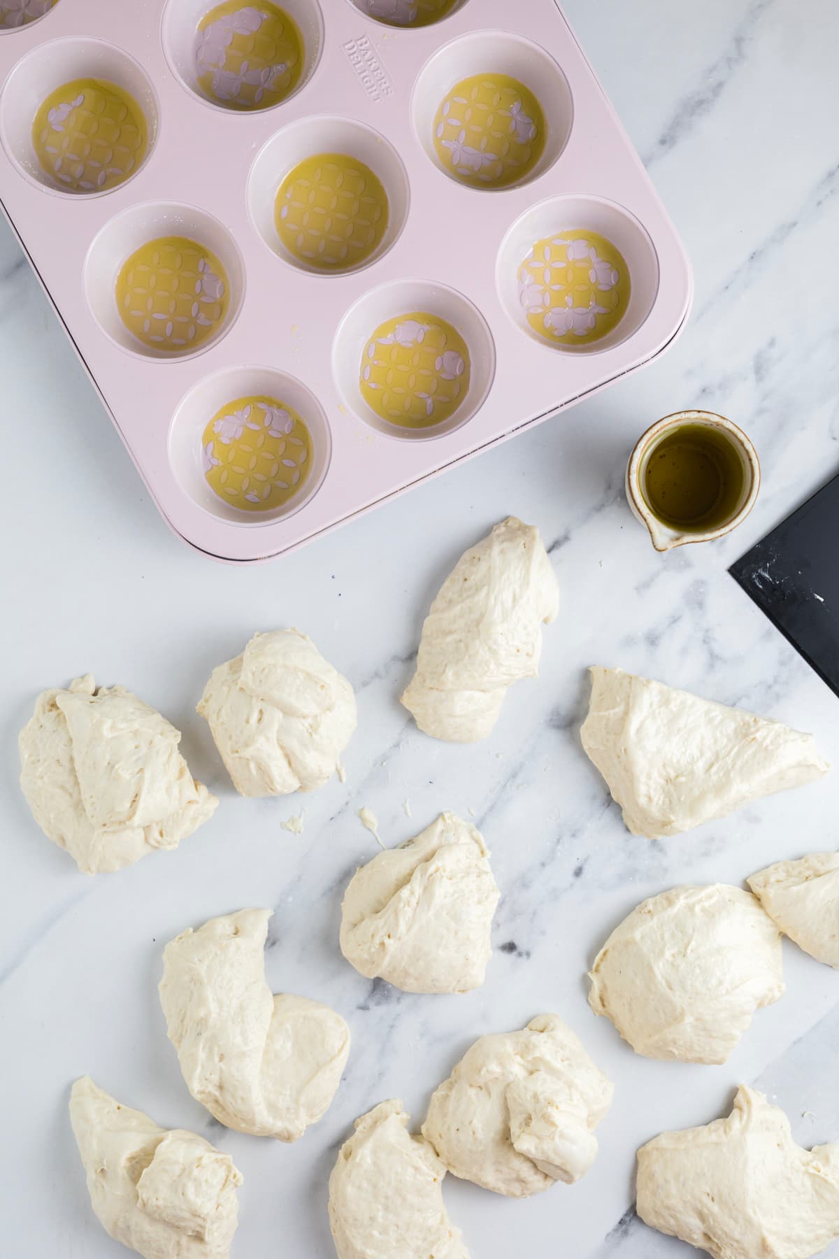 Portions of sourdough focaccia dough divided and ready to shape into muffins.