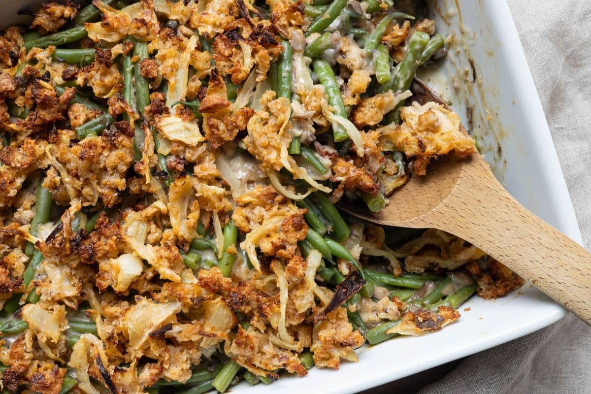 Close up of creamy sourdough green bean casserole with fresh green beans and crispy homemade onion topping.