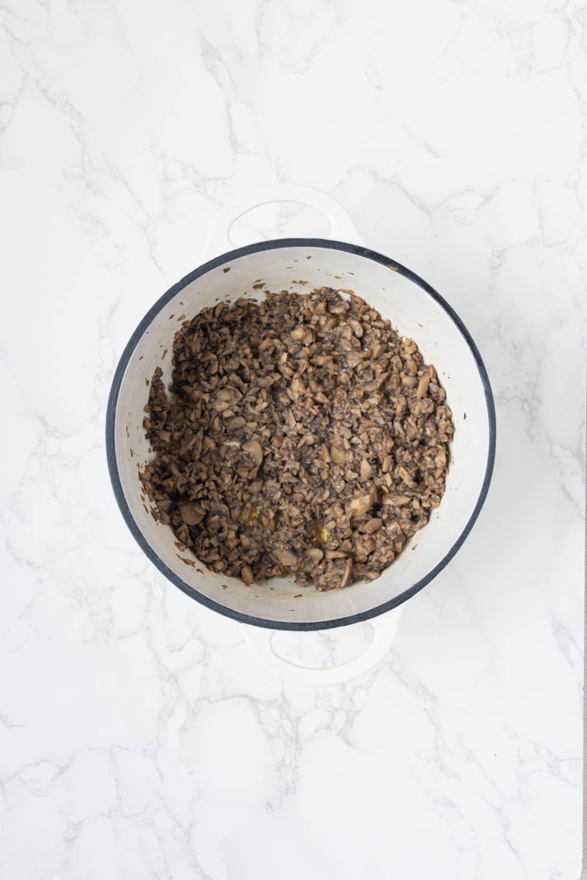 Finely chopped mushrooms cooked until browned for homemade mushroom sauce.