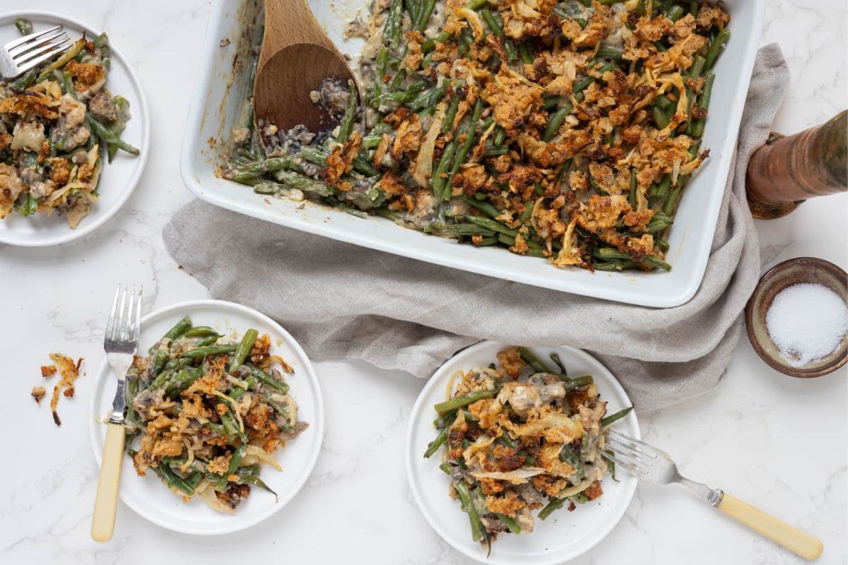 Sourdough green bean casserole served onto plates for a holiday meal.