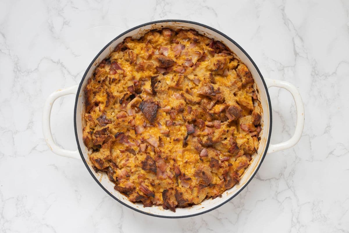Freshly baked sourdough ham and cheese strata before being garnished with sliced green onions.