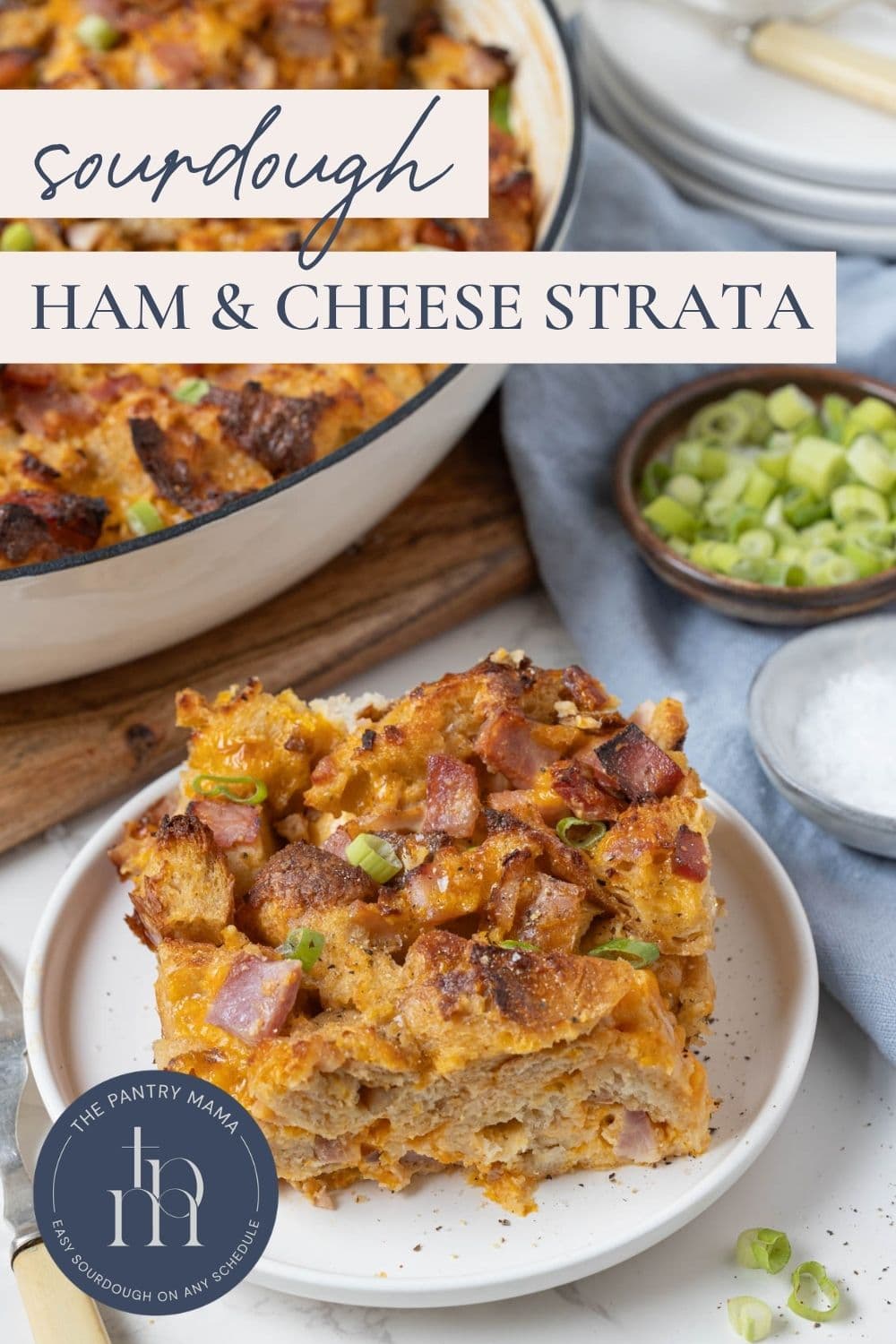 Pinterest graphic featuring a plated serving of sourdough ham and cheese strata with the casserole in the background.