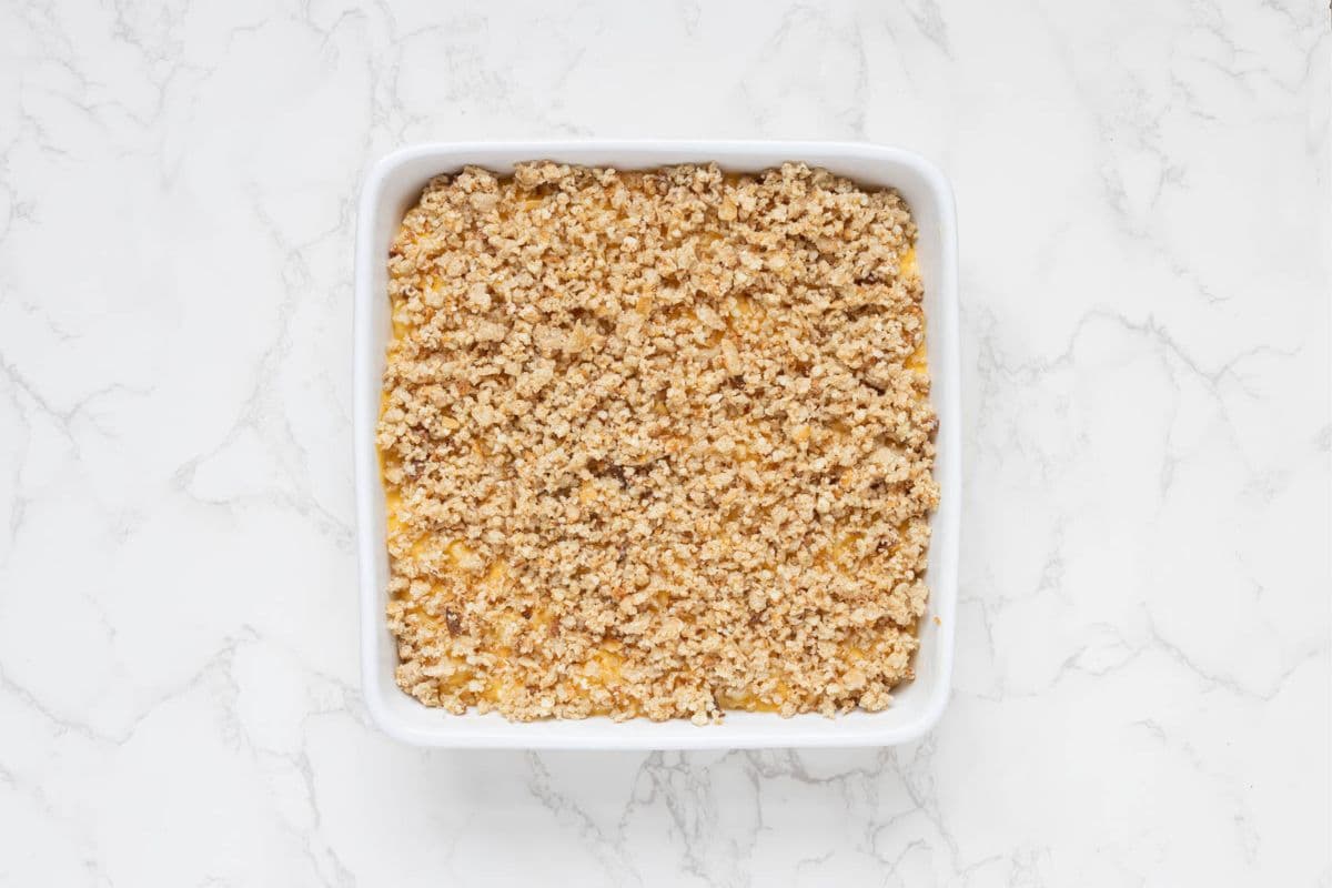 A square baking dish filled with sourdough mac and cheese and topped with sourdough bread crumb topping.