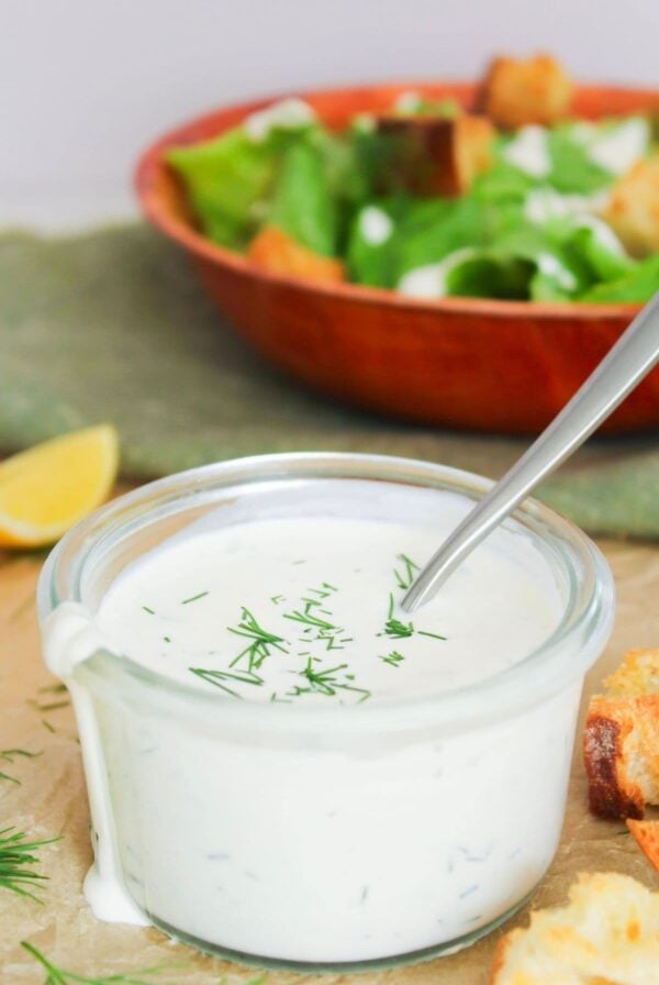 Creamy homemade ranch dressing topped with fresh dill and served with croutons and a salad.