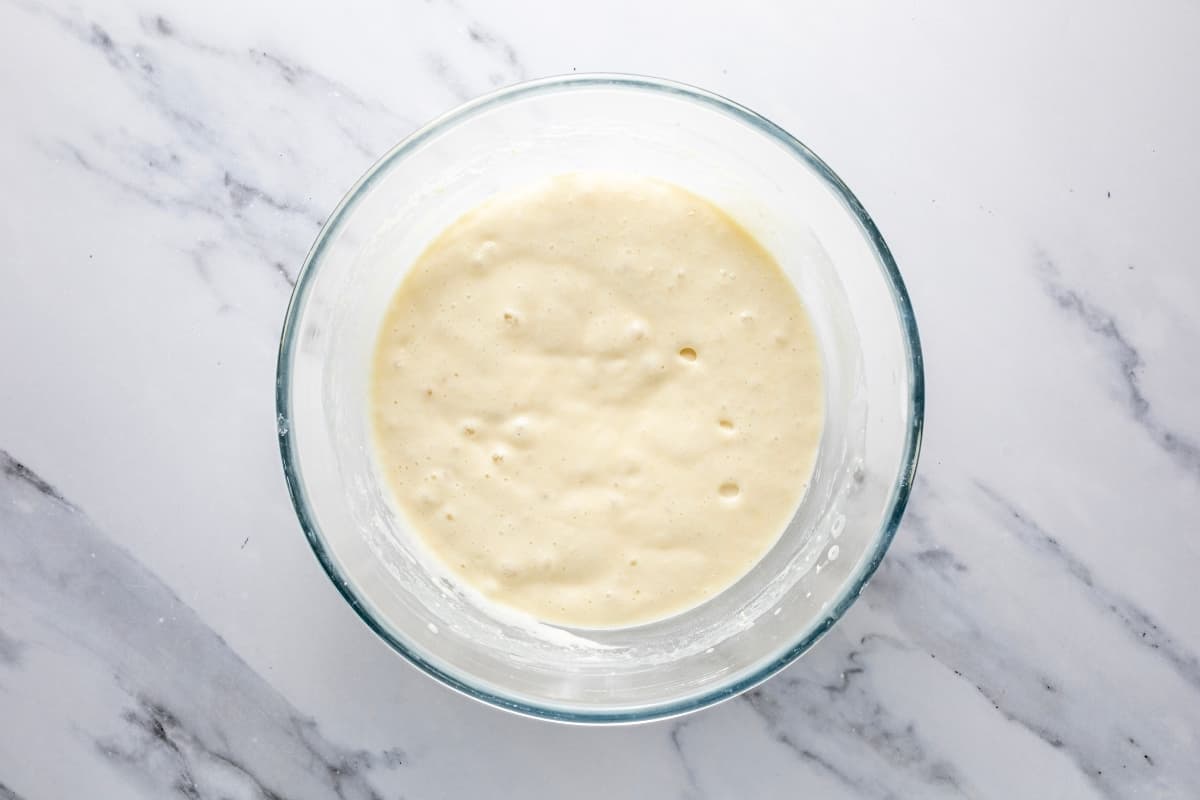 A glass bowl filled with sourdough pancake batter that has been made using homemade sourdough pancake mix.