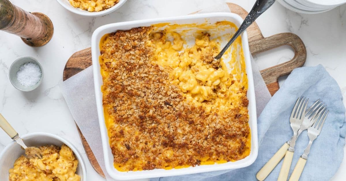 A square baking dish filled with sourdough mac and cheese that has been topped with bread crumbs and baked in the oven.