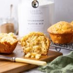 A feature image for Sourdough Muffin Mix. You can see the jar of sourdough muffin mix in the background, with some muffins that have been made using the mix in the foreground. The one in the very front has been sliced open.