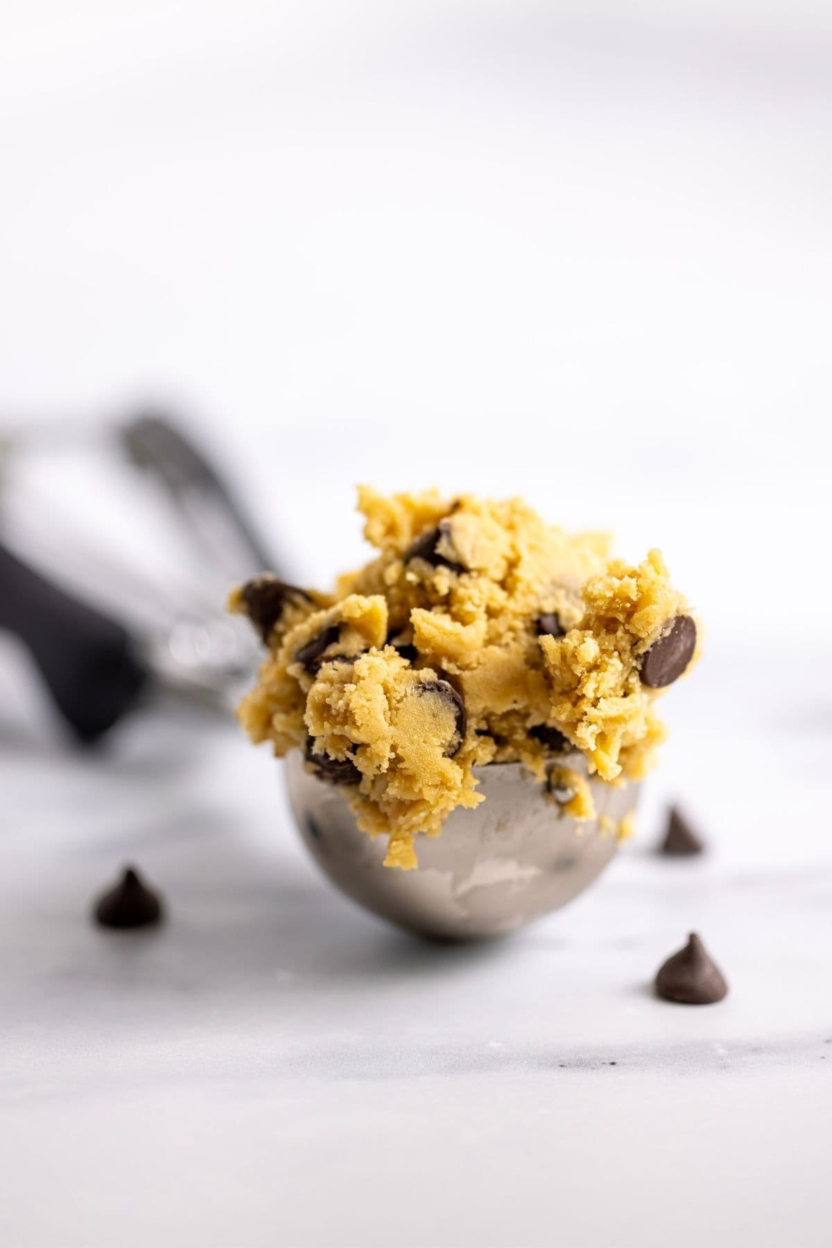 Sourdough discard chocolate chip cookie dough sitting in a 3 tablespoon cookie scoop.