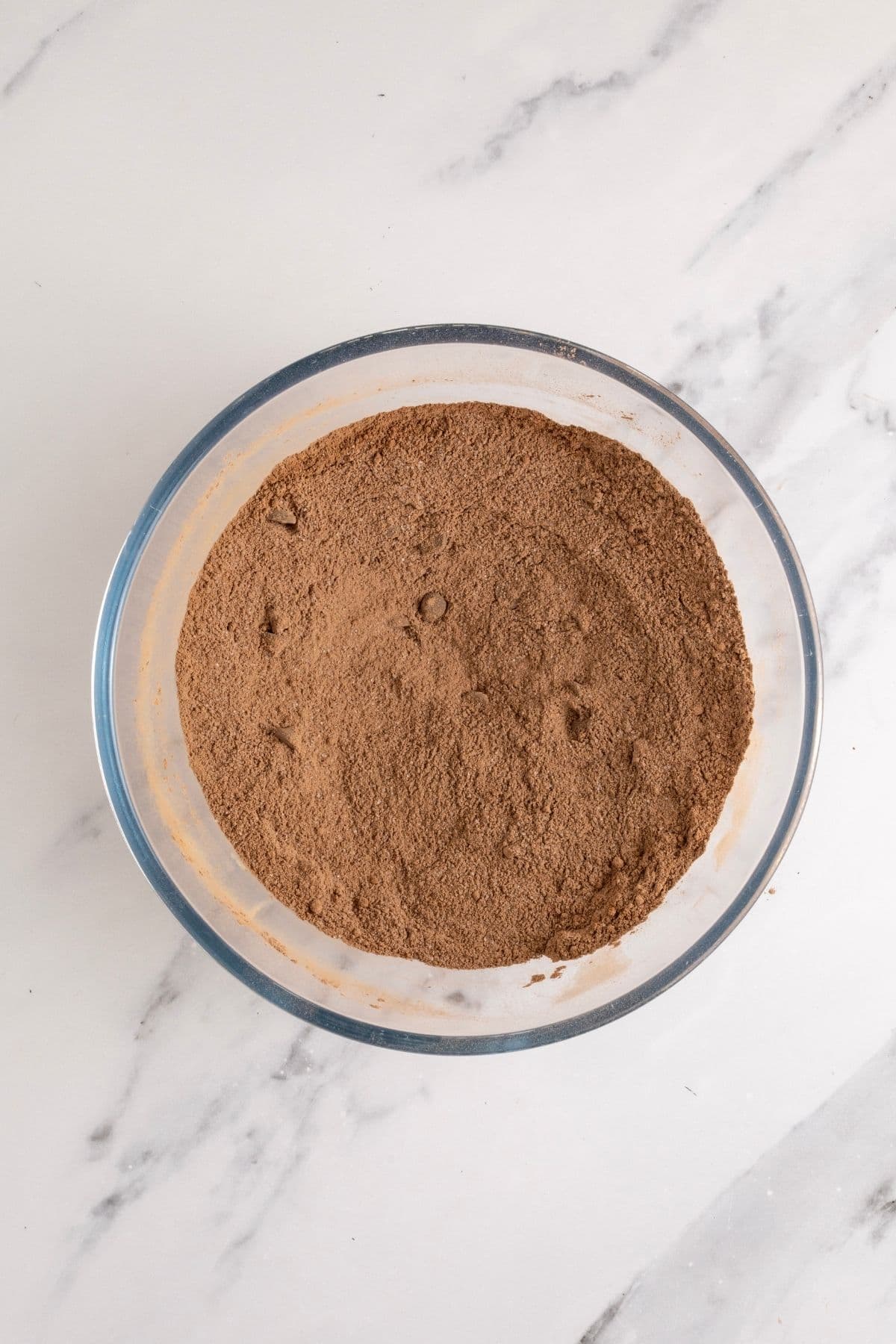 A glass bowl containing the dry ingredients used to make sourdough brownies.