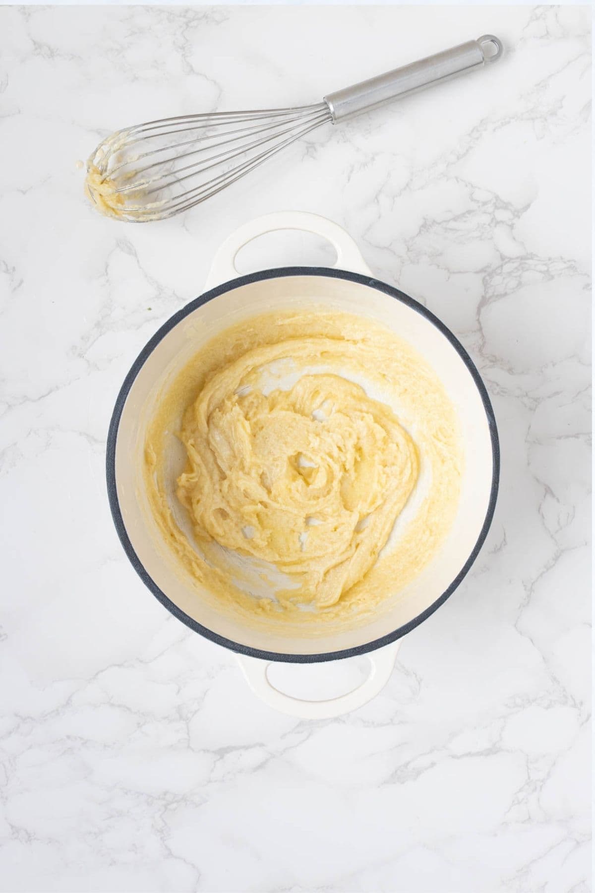 Thickened butter, sourdough starter and milk roux in a saucepan during preparation of the cheese sauce for sourdough broccoli casserole.