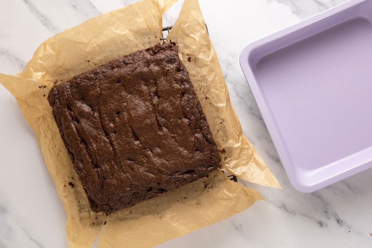 A horizontal photo showing a batch of sourdough brownies that have been taken out of the oven and then out of the pan and allowed to cool on a wire rack.