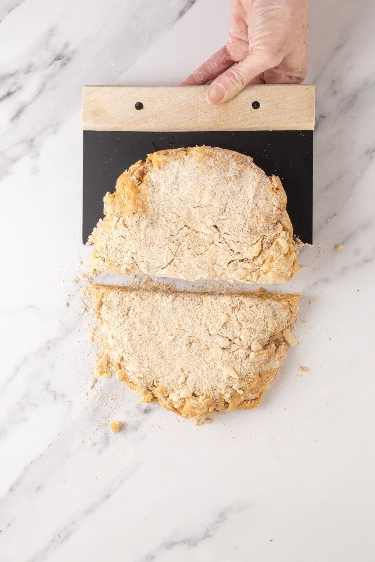 Sourdough pumpkin scone dough that has been cut in half and ready to stack to create flaky layers.