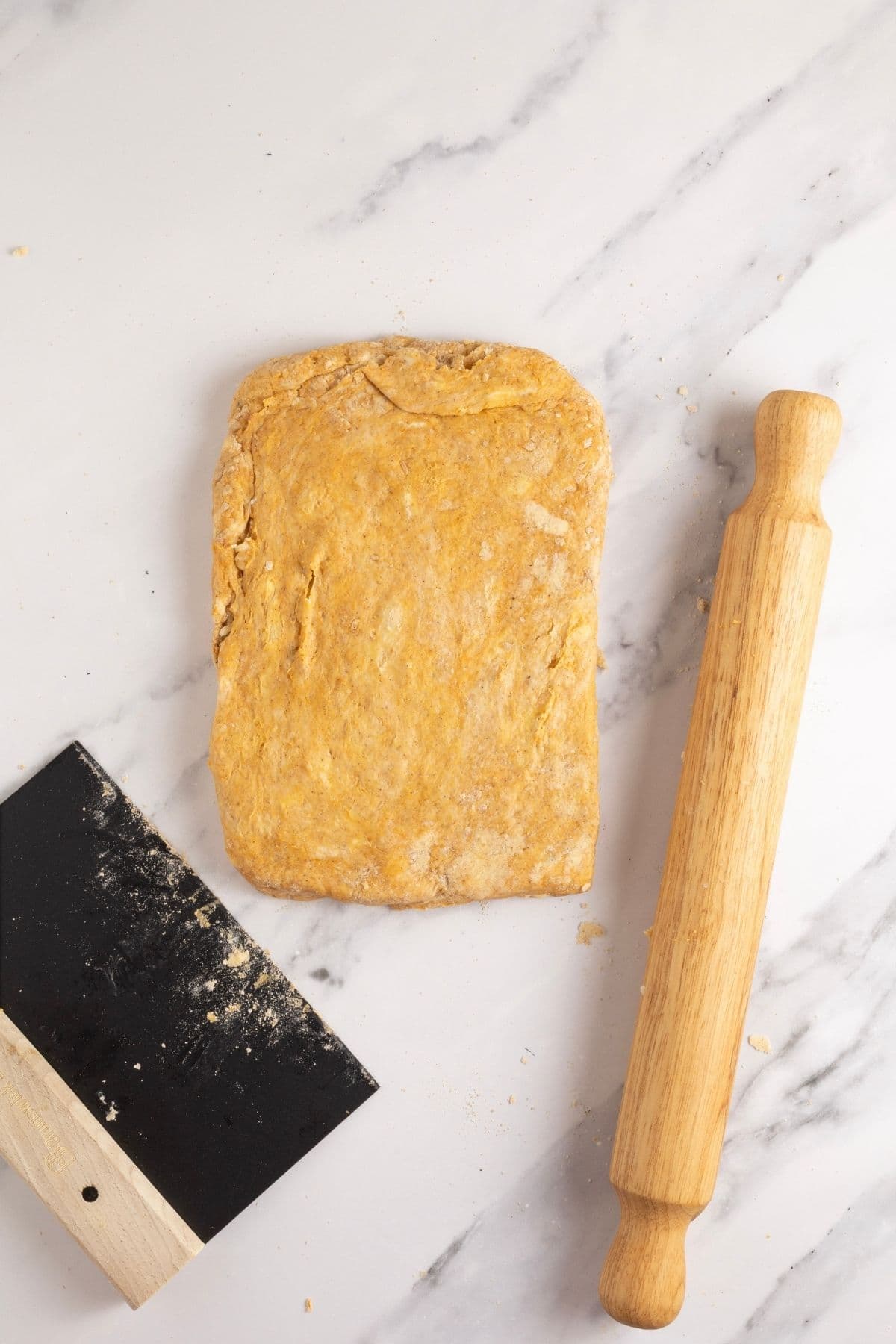 A rectangle of scone dough that has been layered and is ready to cut into 8 equal pieces.