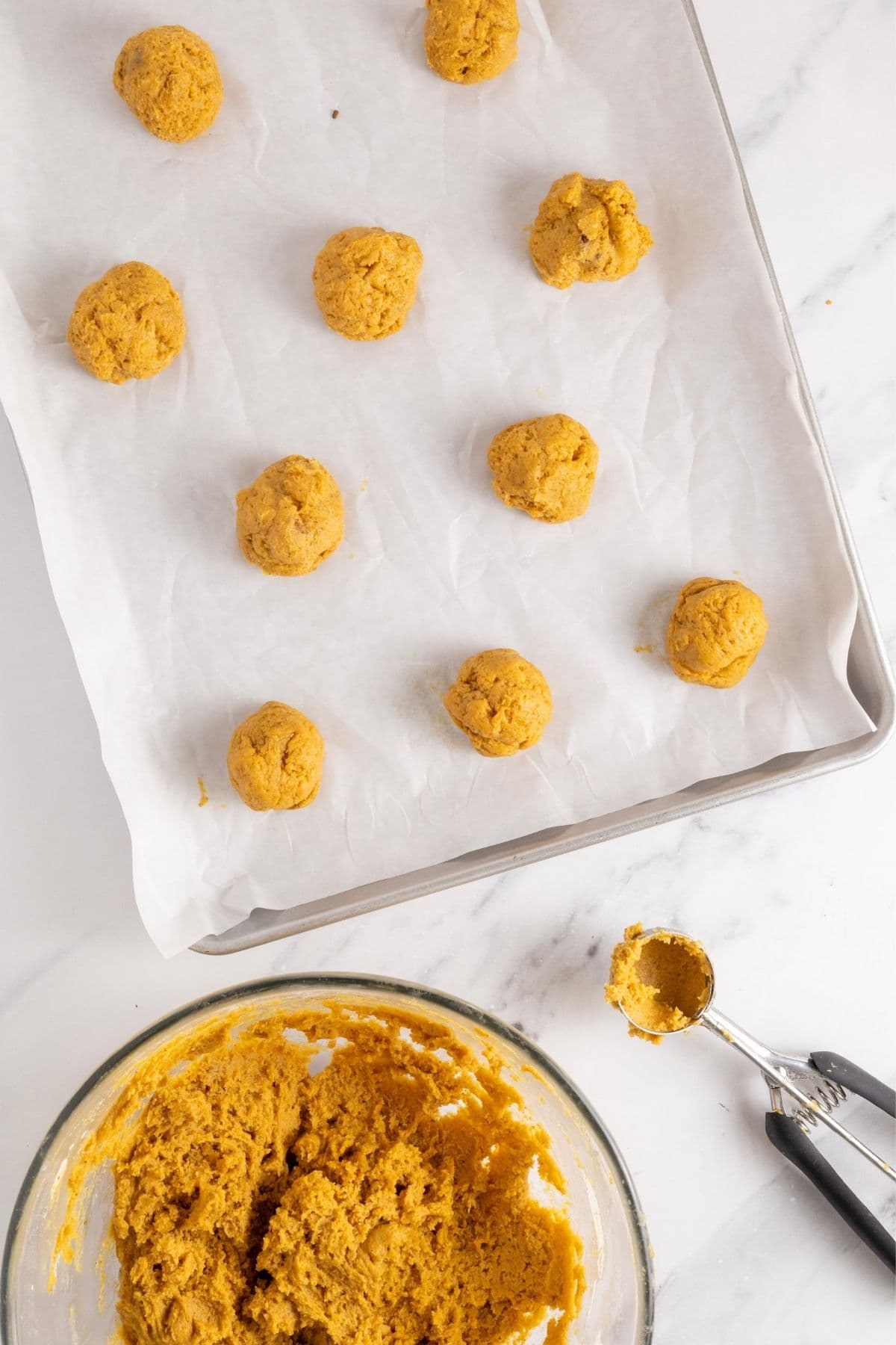 A top down image showing the cookie dough being scooped out on to a cookie tray.